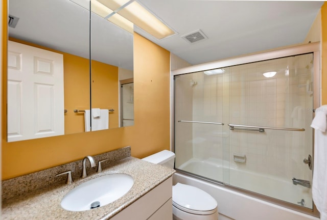 full bathroom featuring shower / bath combination with glass door, vanity, and toilet