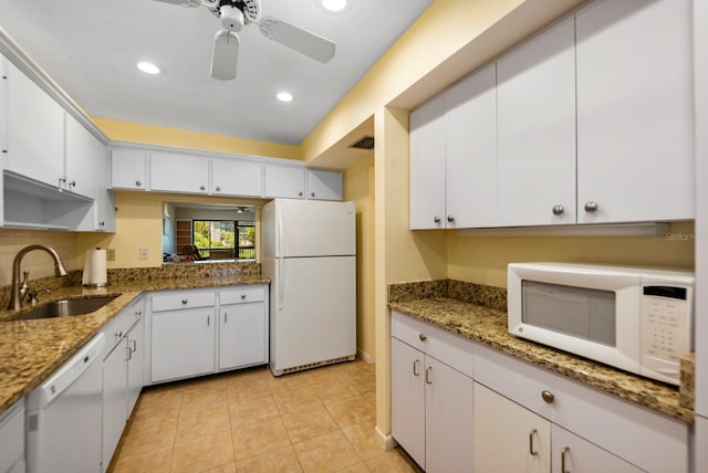 kitchen with white appliances, white cabinets, and sink