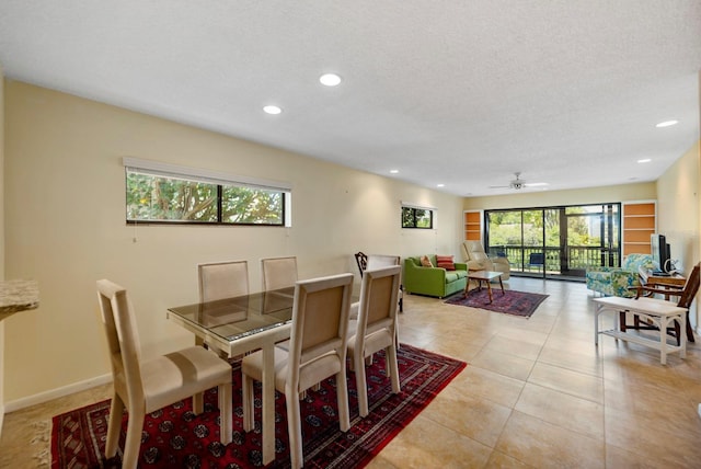 dining space featuring a textured ceiling, ceiling fan, and light tile patterned floors