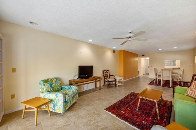 living room featuring a textured ceiling and ceiling fan