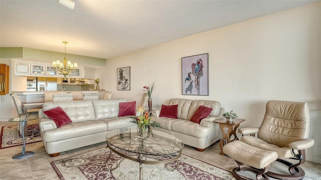 living room with light tile patterned flooring, a notable chandelier, and a textured ceiling