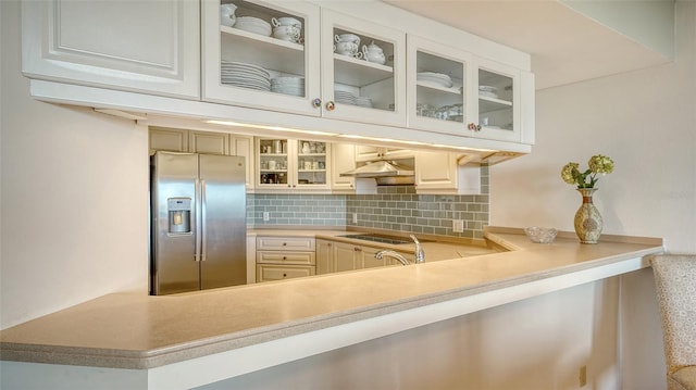 bar with stainless steel refrigerator with ice dispenser, black electric stovetop, and decorative backsplash