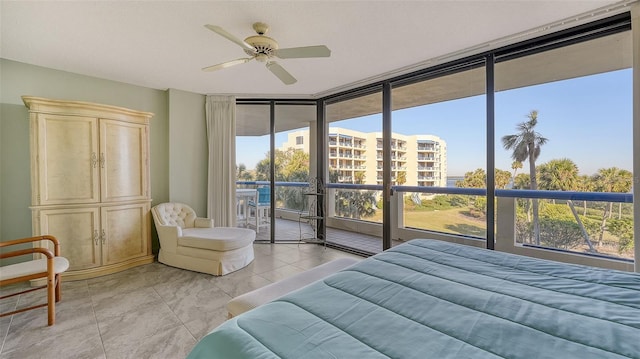 tiled bedroom featuring ceiling fan, access to outside, and a wall of windows