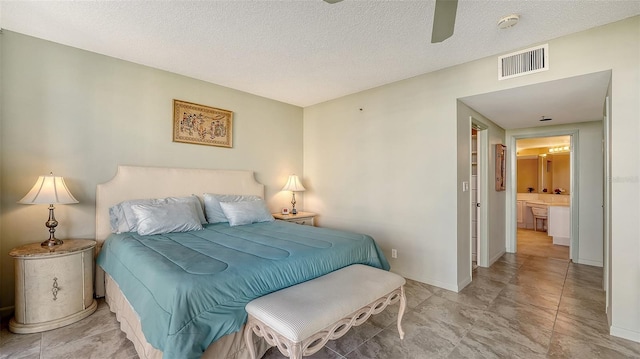 bedroom featuring a textured ceiling, ceiling fan, and ensuite bathroom