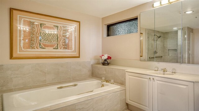 bathroom with vanity and shower with separate bathtub