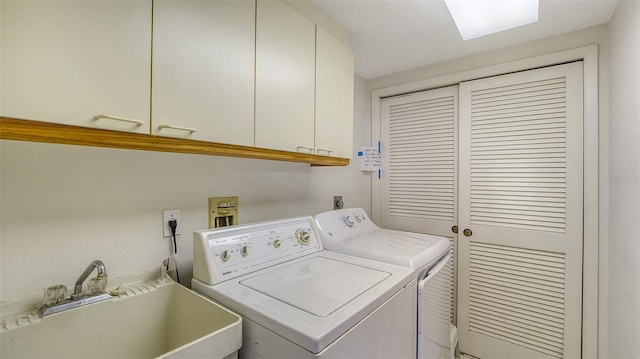 laundry room featuring sink, washing machine and dryer, and cabinets