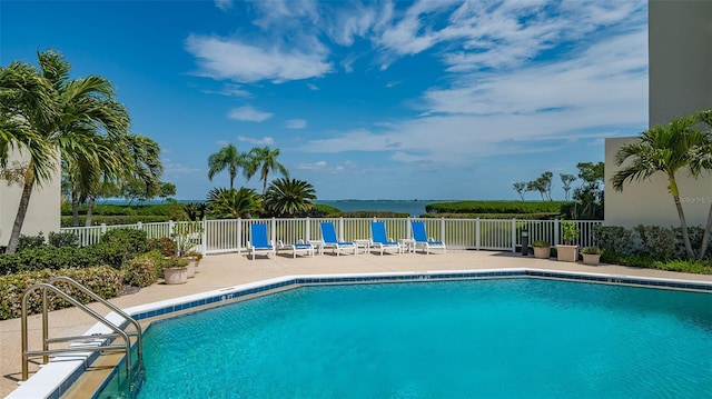 view of pool with a patio area and a water view