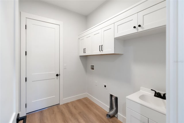 laundry area with electric dryer hookup, light wood-type flooring, washer hookup, cabinets, and sink