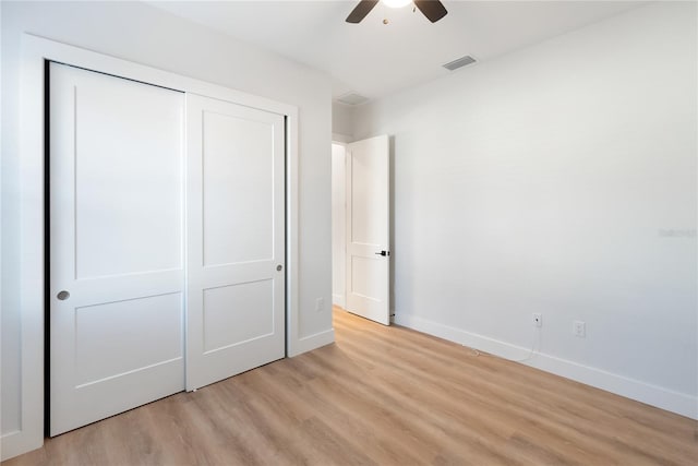 unfurnished bedroom featuring ceiling fan, a closet, and light hardwood / wood-style floors