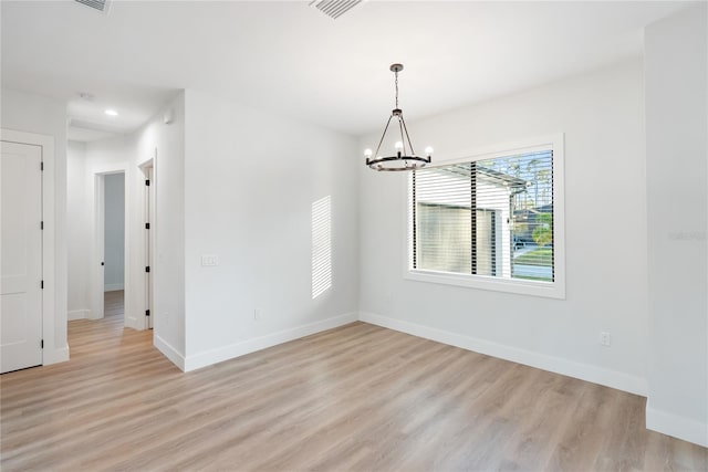 unfurnished dining area with light wood-type flooring and a chandelier