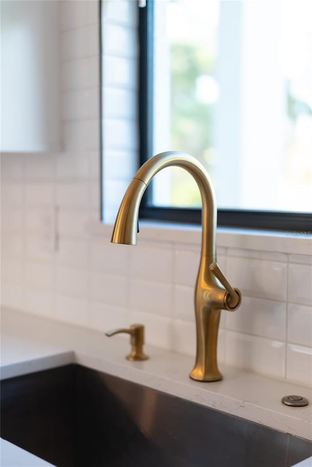 details with white cabinetry, tasteful backsplash, and sink