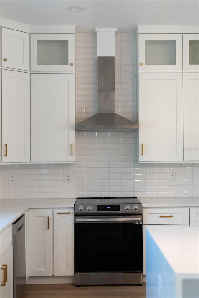 kitchen featuring wall chimney range hood, white cabinetry, and appliances with stainless steel finishes