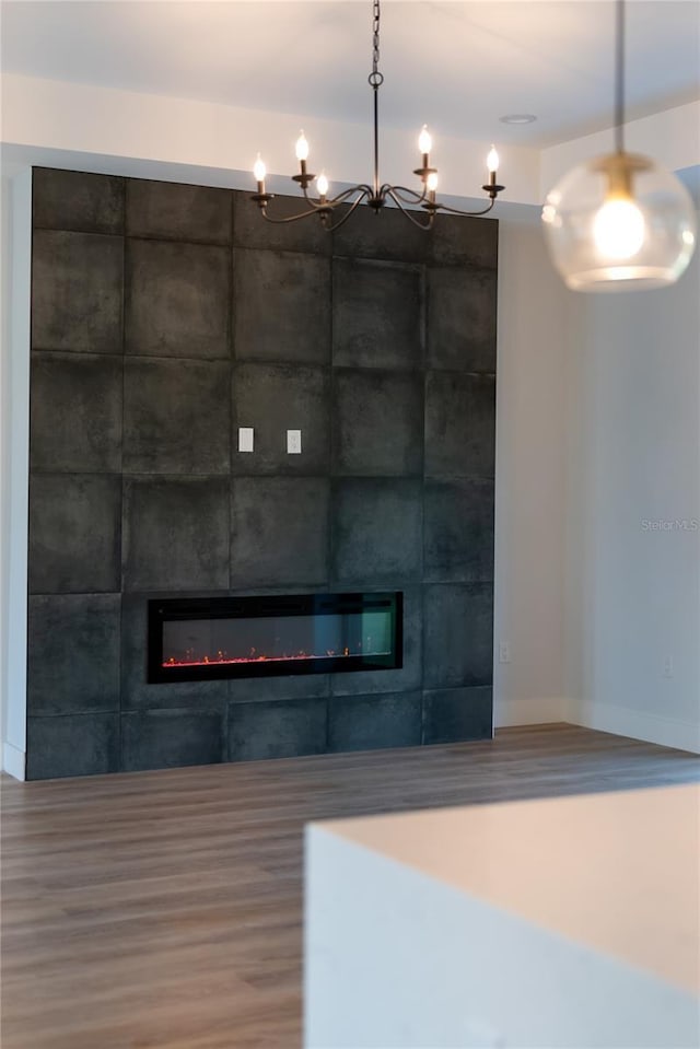 interior space with wood-type flooring and a tiled fireplace