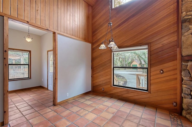 tiled empty room featuring a towering ceiling