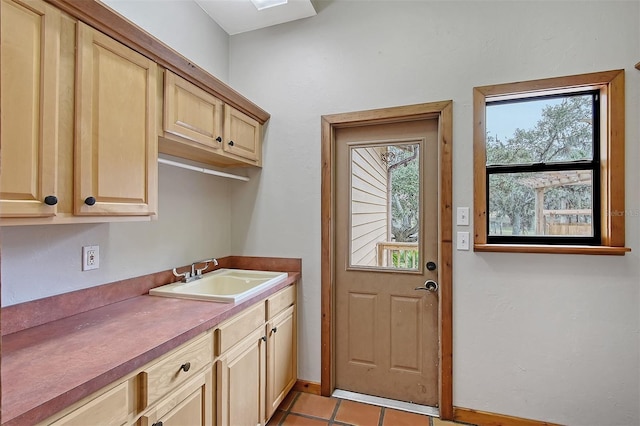 clothes washing area featuring light tile patterned floors and sink