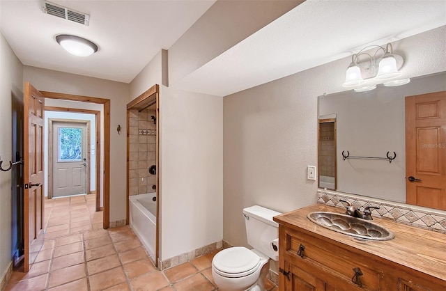 full bathroom featuring toilet, vanity, tiled shower / bath, tile patterned floors, and a chandelier