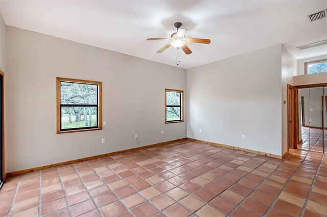 unfurnished room with ceiling fan, tile patterned floors, and a healthy amount of sunlight