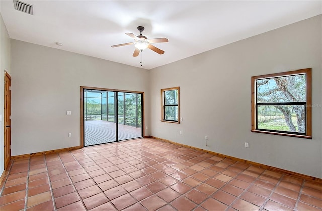 tiled spare room with ceiling fan