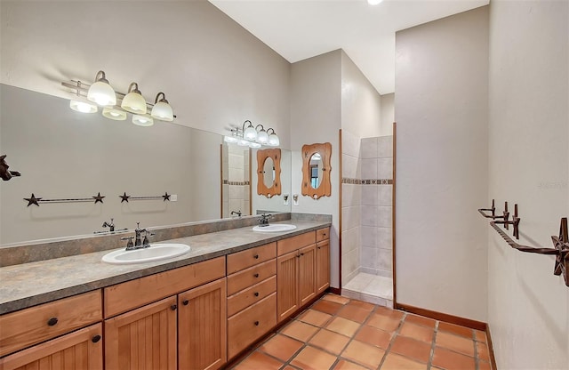 bathroom with vanity, a tile shower, and tile patterned flooring