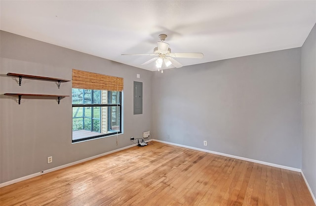 spare room featuring ceiling fan, electric panel, and light hardwood / wood-style floors