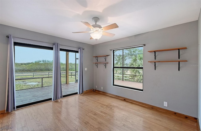 empty room featuring ceiling fan, a healthy amount of sunlight, and light wood-type flooring