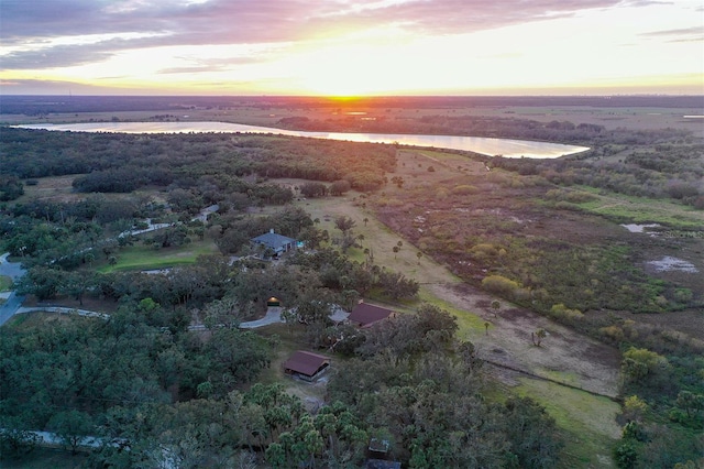 aerial view at dusk featuring a water view