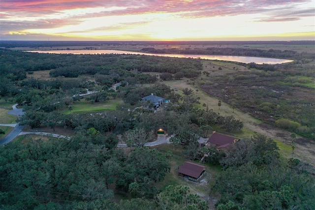 aerial view at dusk featuring a water view