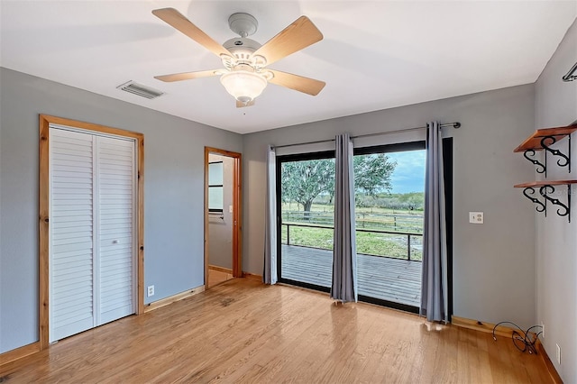 doorway with ceiling fan and light hardwood / wood-style flooring