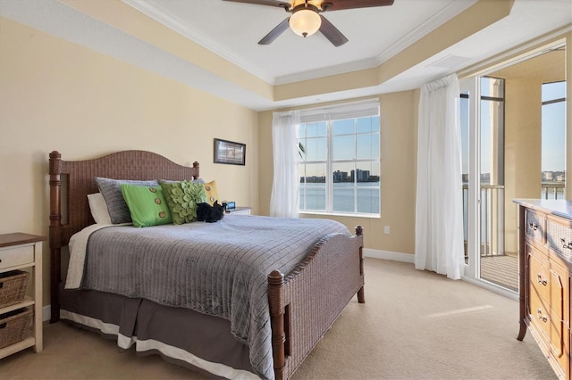 bedroom featuring light carpet, ceiling fan, crown molding, and a tray ceiling