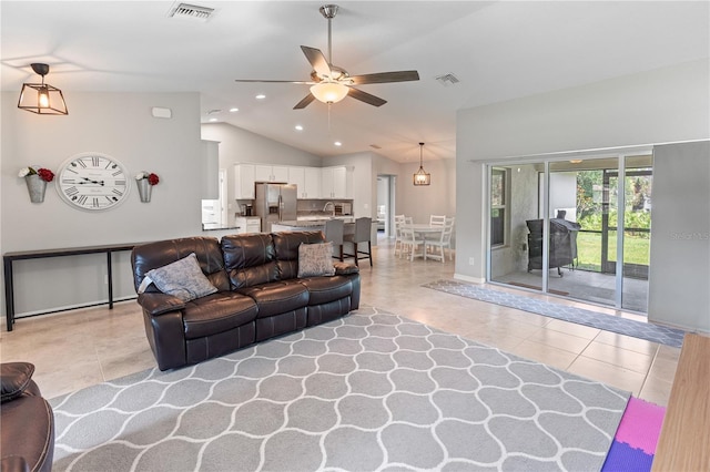 living room featuring ceiling fan, light tile patterned flooring, and lofted ceiling