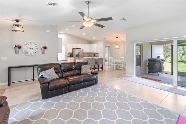 living room with lofted ceiling, light tile patterned flooring, and ceiling fan