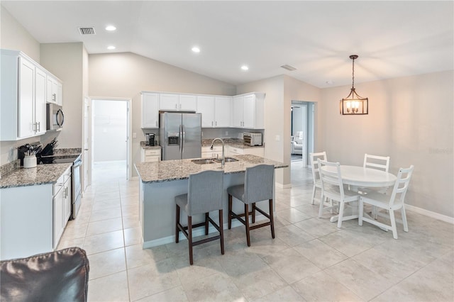 kitchen featuring sink, decorative light fixtures, white cabinetry, stone counters, and appliances with stainless steel finishes