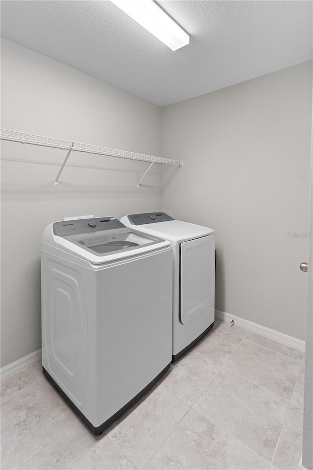 clothes washing area with washing machine and dryer