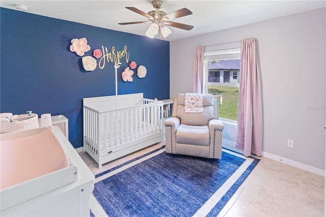 tiled bedroom with ceiling fan, multiple windows, and a nursery area