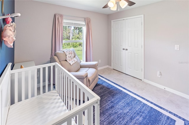 tiled bedroom featuring a crib, a closet, and ceiling fan