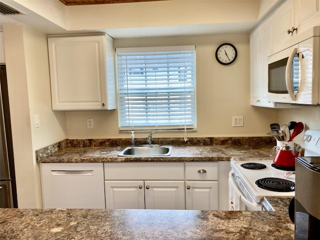 kitchen featuring white appliances, white cabinetry, and sink