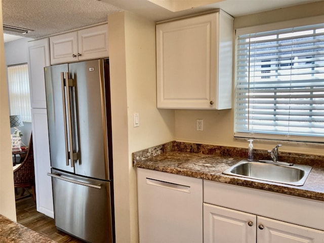 kitchen with white cabinetry, high end refrigerator, dark hardwood / wood-style flooring, a textured ceiling, and sink