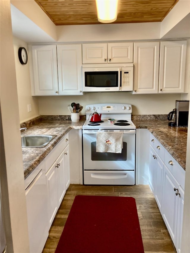 kitchen with wooden ceiling, white appliances, dark stone counters, white cabinets, and sink