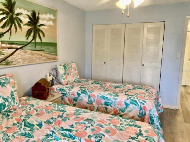 bedroom featuring ceiling fan, a closet, and light wood-type flooring