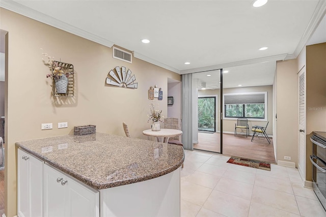 kitchen with light stone counters, visible vents, crown molding, and white cabinetry