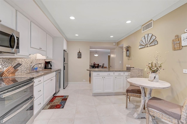 kitchen with white cabinetry, stainless steel appliances, sink, backsplash, and crown molding