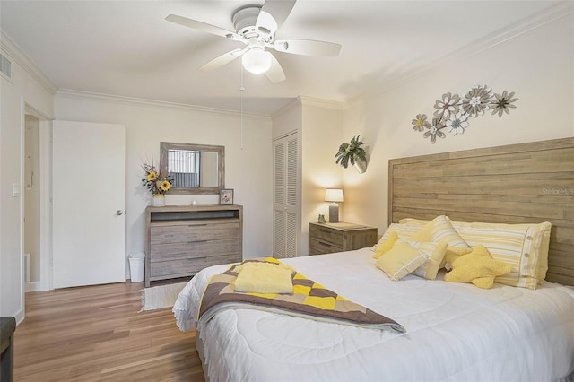 bedroom featuring ceiling fan, hardwood / wood-style floors, a closet, and ornamental molding