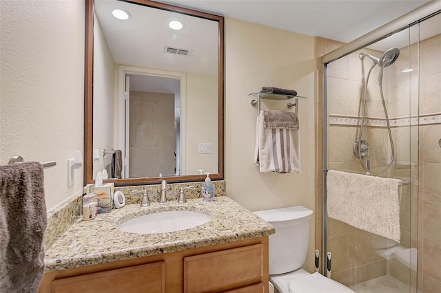 bathroom featuring visible vents, toilet, a stall shower, recessed lighting, and vanity