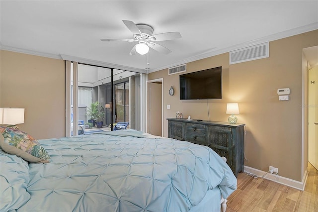 bedroom featuring visible vents, light wood-style floors, and ornamental molding