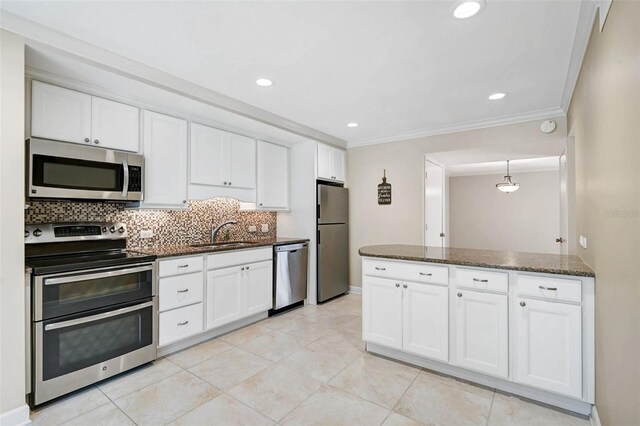 304 Pine Run Dr, Osprey, FL 34229 - kitchen featuring appliances with stainless steel finishes, a sink, tasteful backsplash, white cabinetry, and ornamental molding