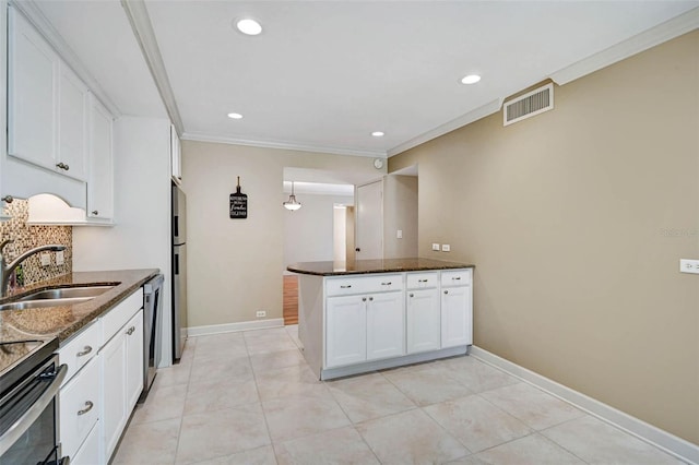 304 Pine Run Dr, Osprey, FL 34229 - kitchen with a sink, stainless steel appliances, dark stone counters, white cabinets, and crown molding
