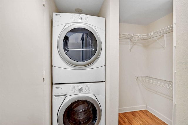 304 Pine Run Dr, Osprey, FL 34229 - laundry area with stacked washer / dryer, wood finished floors, and baseboards