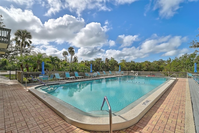 304 Pine Run Dr, Osprey, FL 34229 - community pool with fence, a patio, and view of scattered trees