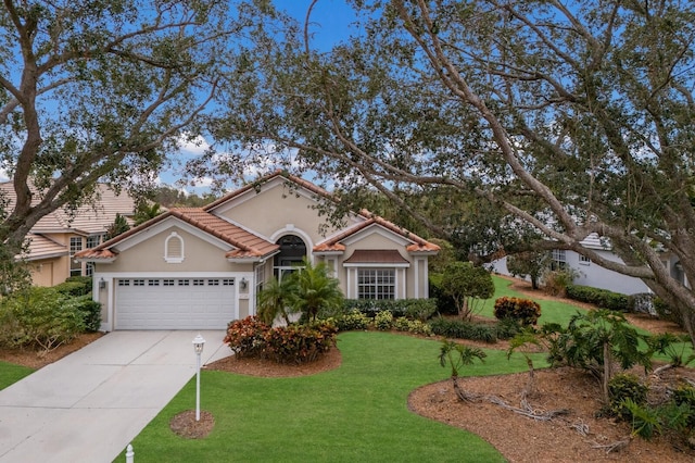 mediterranean / spanish home featuring a garage and a front yard