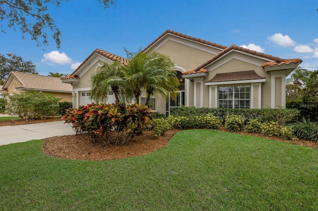 mediterranean / spanish home featuring a garage and a front yard